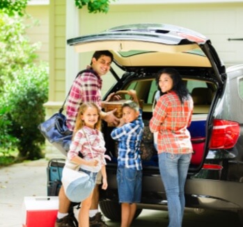 Mother, father and kids at back of mini van