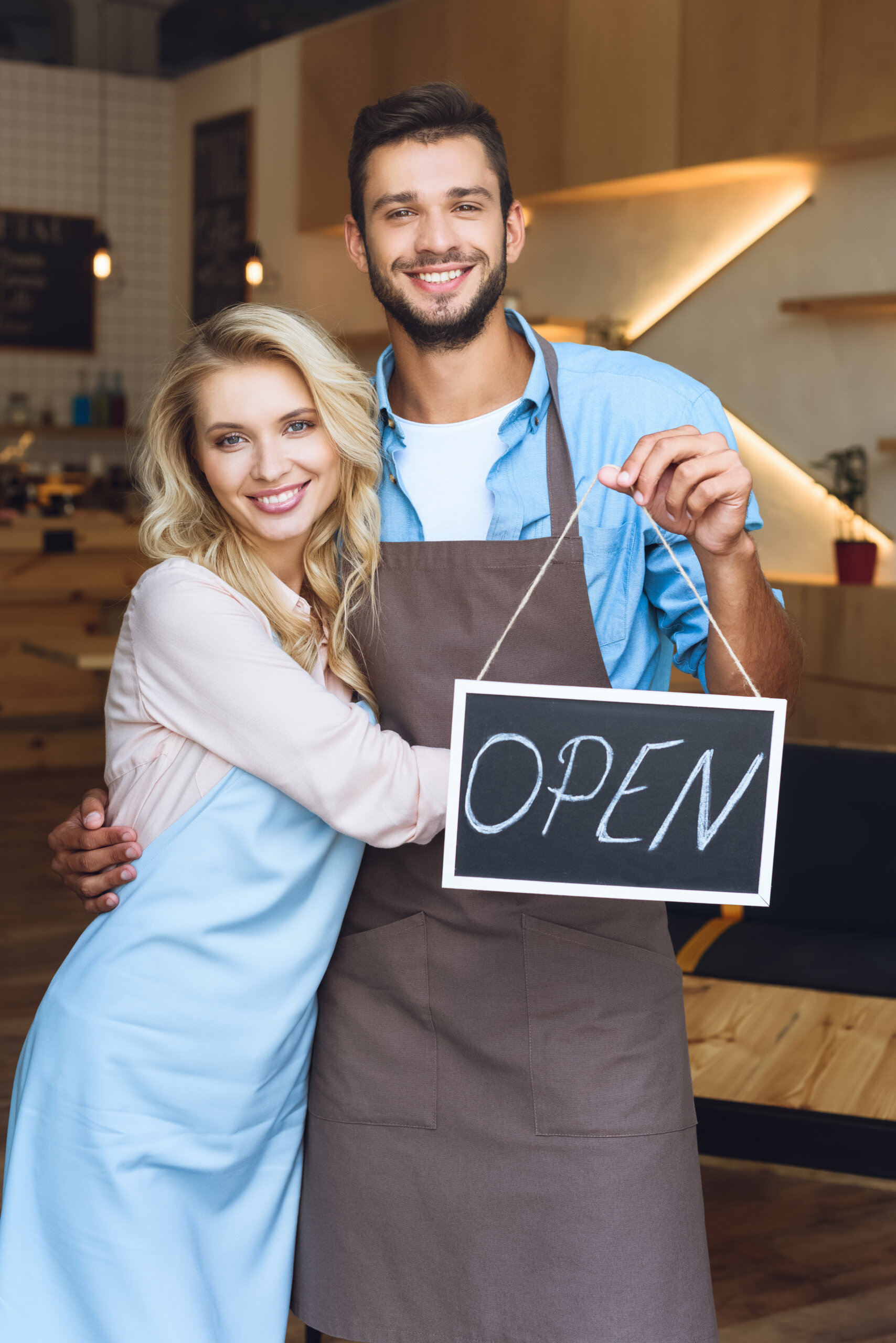 man standing in an apron with an open sign