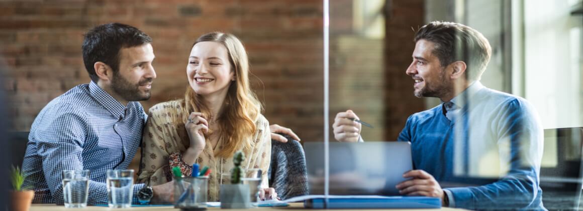 couple with an insurance advisor in his office