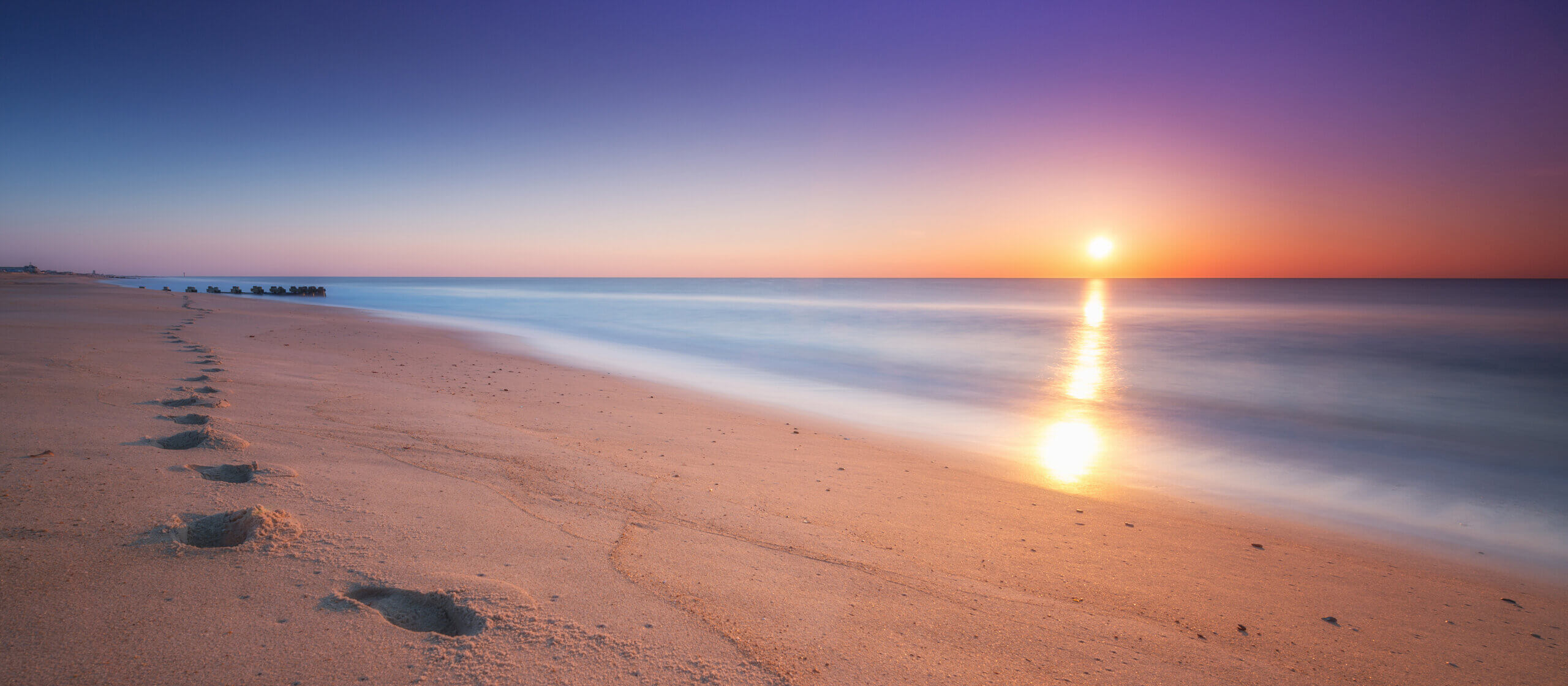 sun set in sea girt nj Foot steps in the sand at the Jersey Shore.