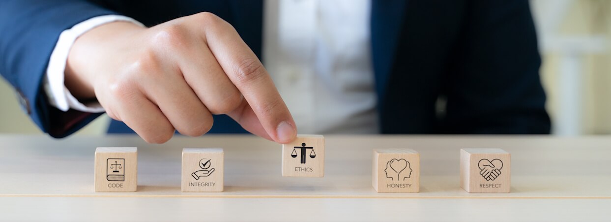 Code of conduct in business concept. Wooden blocks with code of conduct icons; code, integrity, honesty, respect, and ethics, the foundation of a strong corporate code of conduct. Corporate ethics.